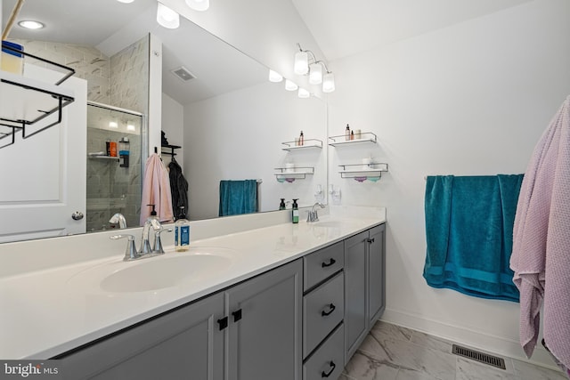 bathroom featuring marble finish floor, double vanity, a sink, and visible vents