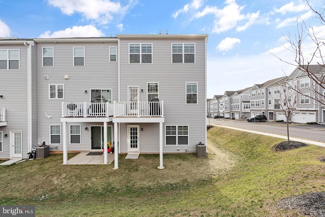 rear view of house featuring a yard, a patio, and central AC unit