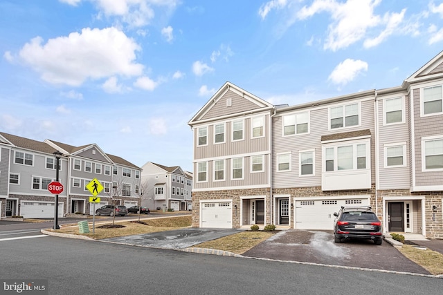 multi unit property featuring driveway, a garage, and a residential view