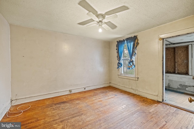 unfurnished room with a textured ceiling, a ceiling fan, and hardwood / wood-style floors