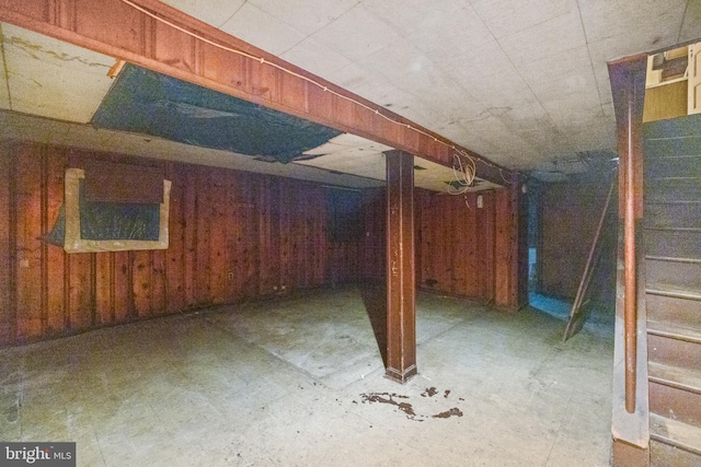 unfinished basement with wooden walls and stairs