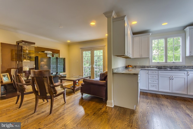 kitchen with french doors, a healthy amount of sunlight, wood finished floors, and crown molding