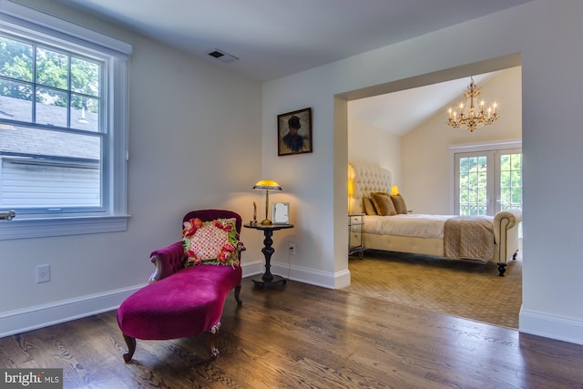 bedroom featuring visible vents, baseboards, a chandelier, lofted ceiling, and wood finished floors