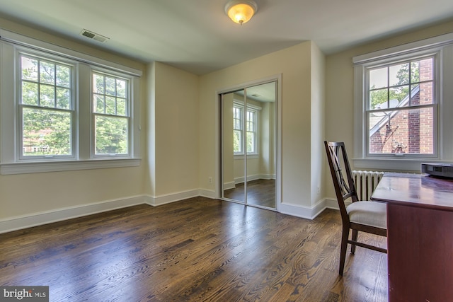 unfurnished office featuring radiator heating unit, visible vents, dark wood-style flooring, and baseboards