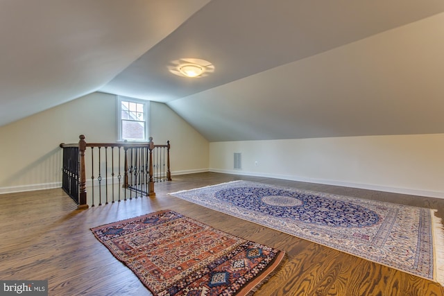 bonus room featuring vaulted ceiling, visible vents, baseboards, and wood finished floors