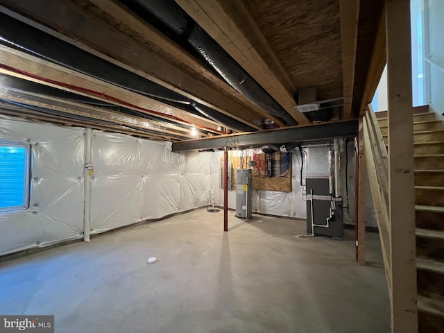 unfinished basement featuring electric water heater and stairs