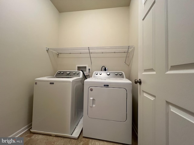 laundry room with laundry area, washing machine and dryer, and baseboards