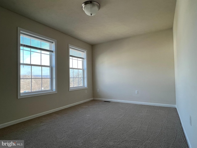 empty room featuring carpet flooring and baseboards