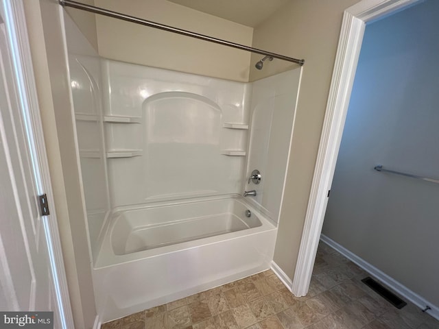 bathroom featuring visible vents, baseboards, and tub / shower combination