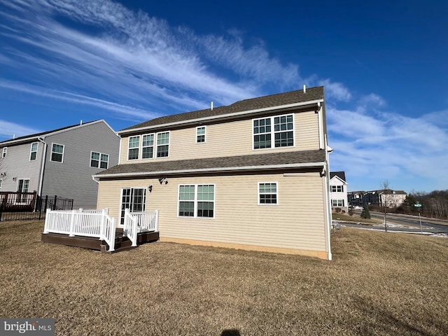 back of house with a deck and a yard