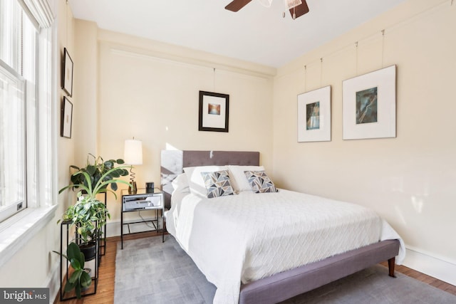 bedroom featuring ceiling fan, baseboards, and wood finished floors