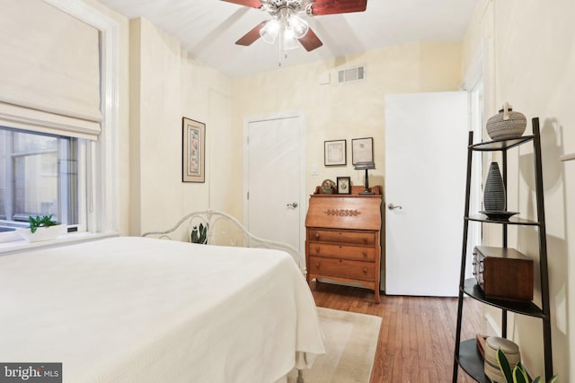 bedroom with visible vents, ceiling fan, and wood finished floors