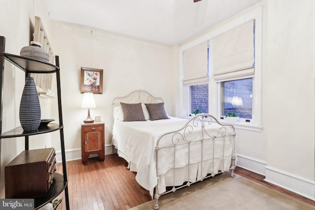 bedroom featuring hardwood / wood-style flooring and baseboards