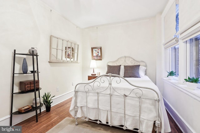 bedroom featuring baseboards and wood finished floors