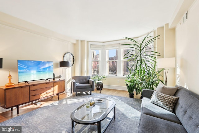 living room featuring visible vents, baseboards, and wood finished floors