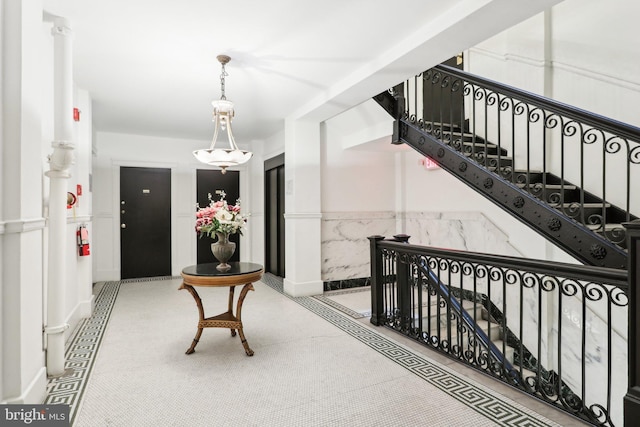 hallway with a wainscoted wall and stairs