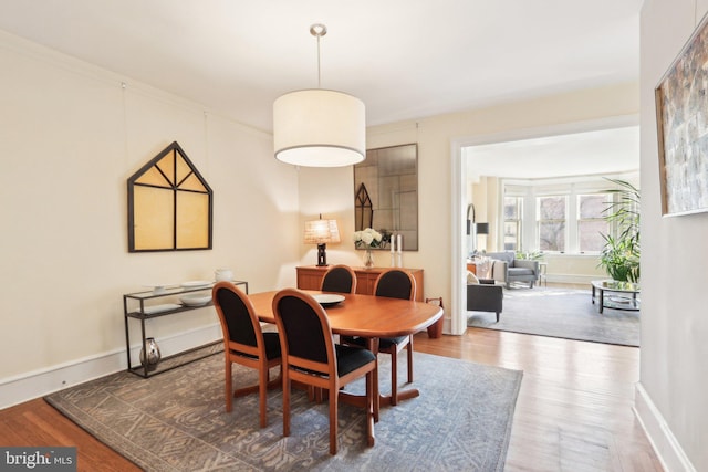 dining area with baseboards and wood finished floors