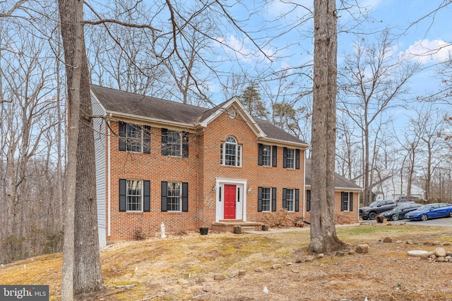 view of front of home with brick siding and roof with shingles