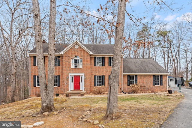 view of front of property with brick siding and roof with shingles