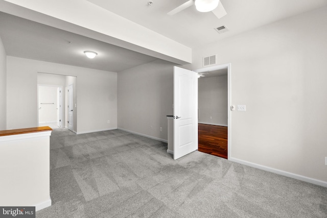 spare room with baseboards, visible vents, ceiling fan, and carpet flooring