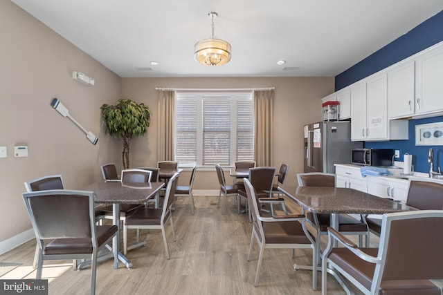 dining room with recessed lighting, baseboards, and light wood finished floors