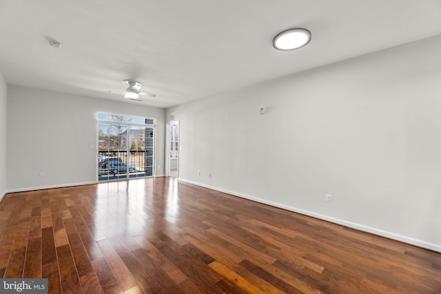 spare room with a ceiling fan, baseboards, and wood finished floors