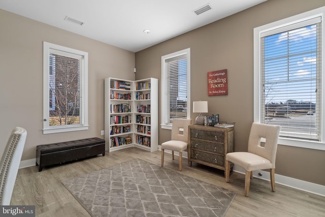 sitting room featuring wood finished floors, visible vents, and baseboards