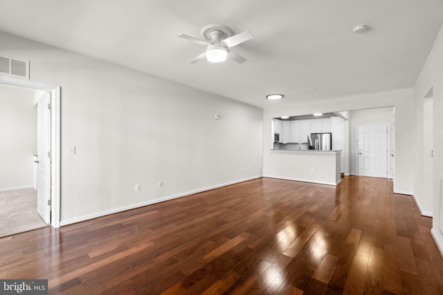 unfurnished living room with ceiling fan, dark wood-style flooring, visible vents, and baseboards