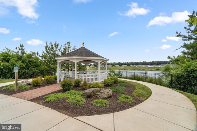 view of home's community with a water view, fence, and a gazebo