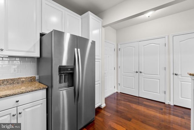 kitchen with decorative backsplash, stainless steel fridge with ice dispenser, dark wood-style flooring, light stone countertops, and white cabinetry