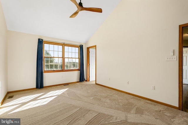 empty room with high vaulted ceiling, carpet flooring, visible vents, and baseboards