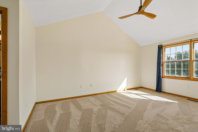 unfurnished room featuring carpet floors, visible vents, a ceiling fan, vaulted ceiling, and baseboards