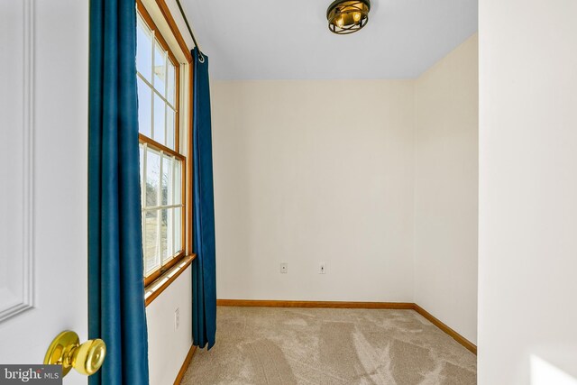 carpeted spare room with baseboards