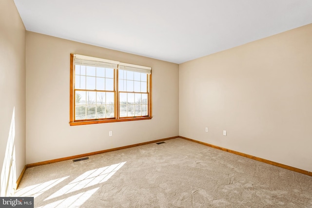 unfurnished room with visible vents, baseboards, and carpet flooring