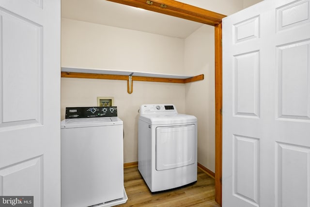 laundry room featuring washer and dryer, laundry area, light wood-style flooring, and baseboards