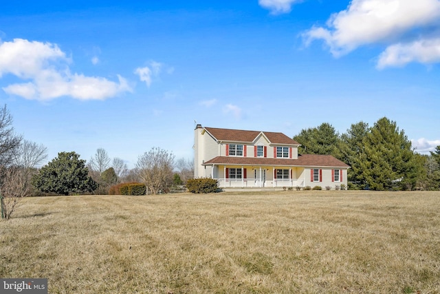 view of front facade featuring covered porch, a chimney, and a front yard