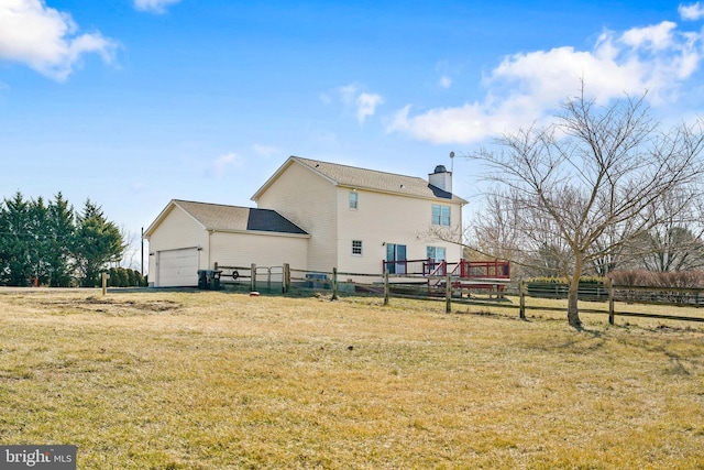 back of house with a yard, a chimney, an attached garage, and fence