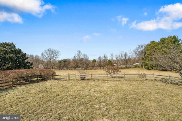 view of yard with a rural view and fence