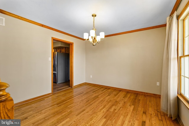 unfurnished room with light wood-type flooring, baseboards, a chandelier, and ornamental molding