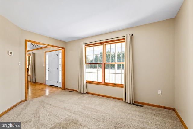 unfurnished room with carpet and baseboards