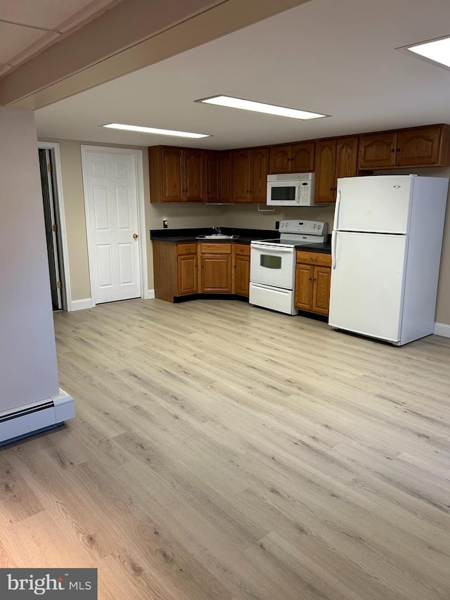 kitchen with white appliances, a sink, baseboard heating, light wood-type flooring, and dark countertops