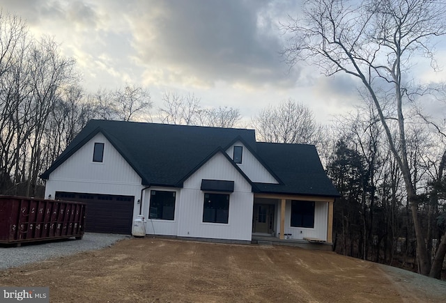 modern farmhouse style home featuring gravel driveway and roof with shingles