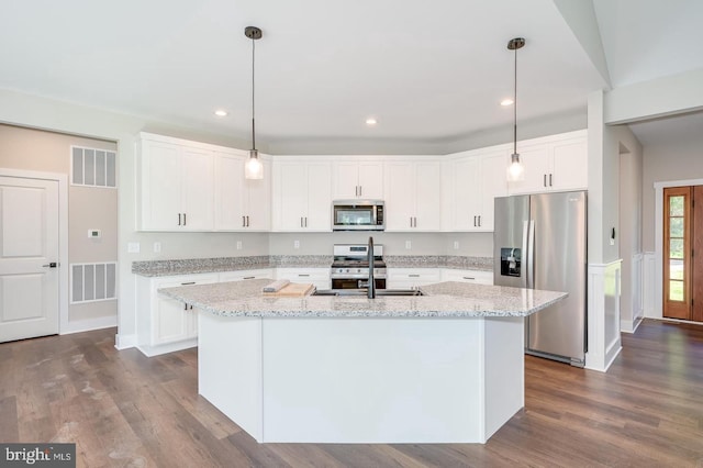 kitchen with dark wood-style floors, white cabinetry, visible vents, and stainless steel appliances