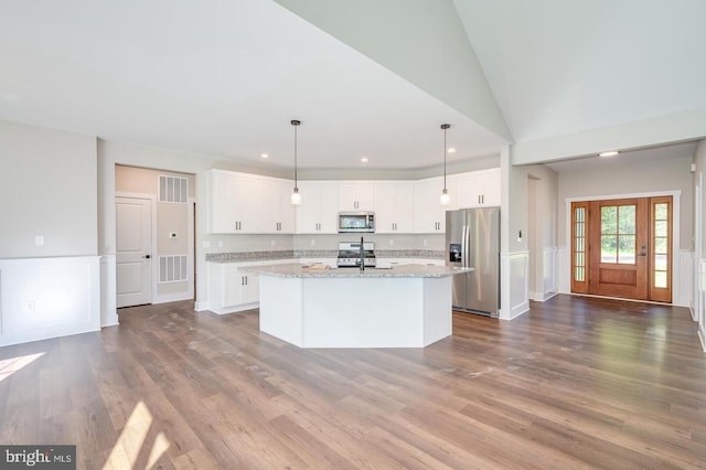 kitchen featuring stainless steel appliances, visible vents, dark wood finished floors, and white cabinetry