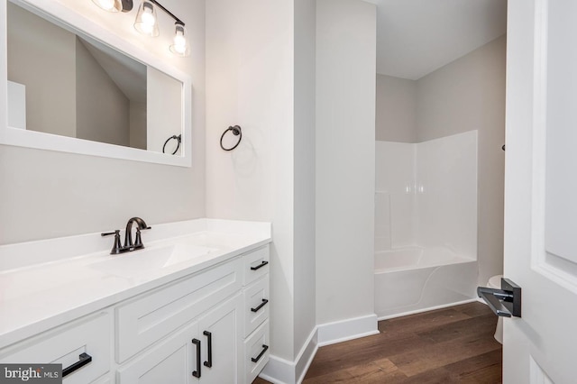 full bathroom featuring baseboards, shower / bathing tub combination, wood finished floors, and vanity