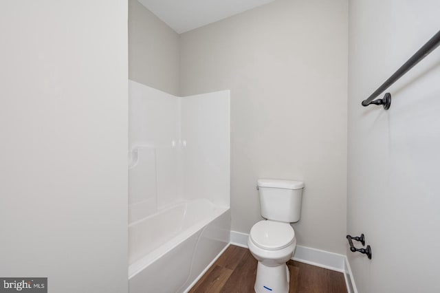 bathroom with shower / bath combination, baseboards, toilet, and wood finished floors