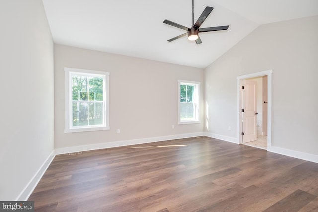 unfurnished room featuring dark wood finished floors, plenty of natural light, and baseboards