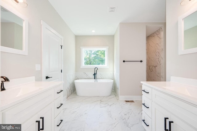 full bath with visible vents, a sink, marble finish floor, a freestanding tub, and two vanities