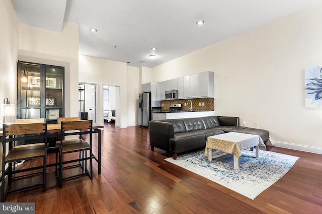 living area featuring dark wood-style flooring, recessed lighting, and baseboards