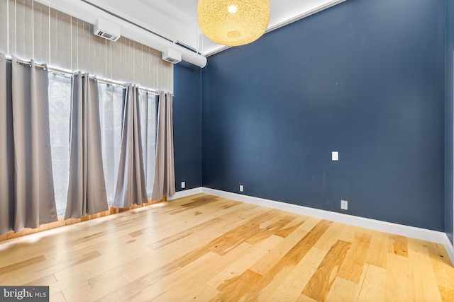 unfurnished room with baseboards and wood finished floors